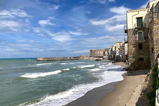 A beach in Cagliari, Italy, with stone houses along the shoreline